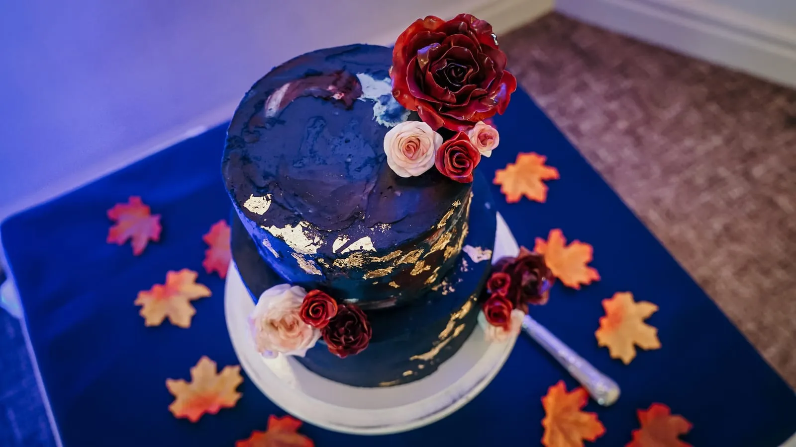 creative, artistic navy wedding cake with autmn leaf decoration