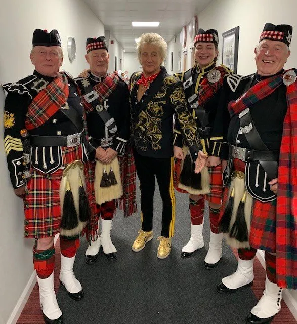 The bagpipers pose with Sir Rod