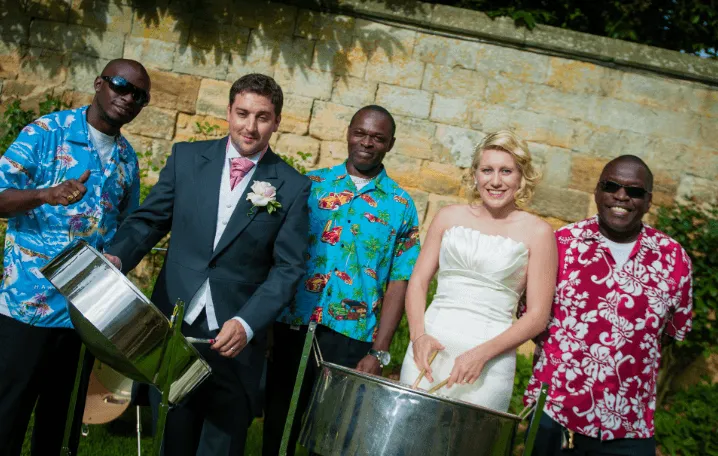 bride and groom playing the steel drums with three steal drum players, smiling, having fun