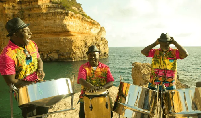 three men playing the steel drums at the beach