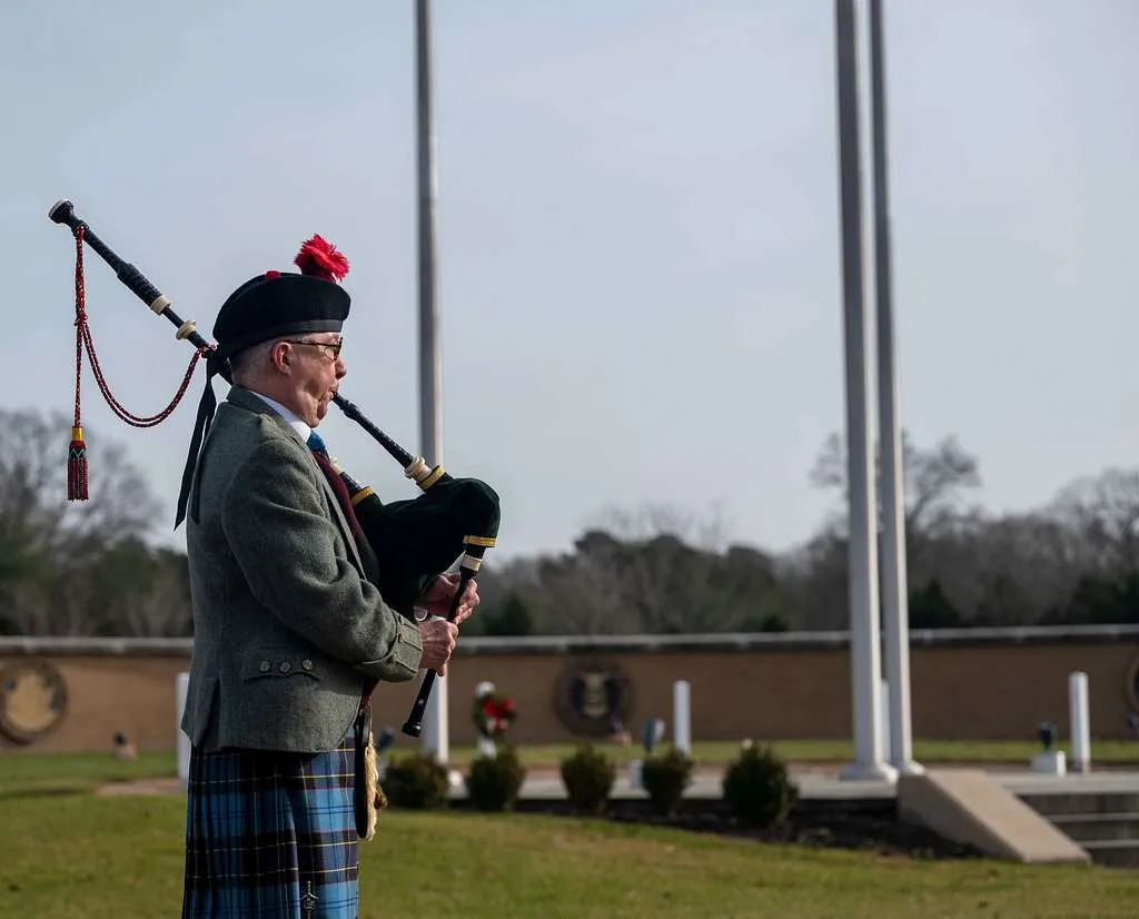 one bagpipe player playing in ceremonial attire