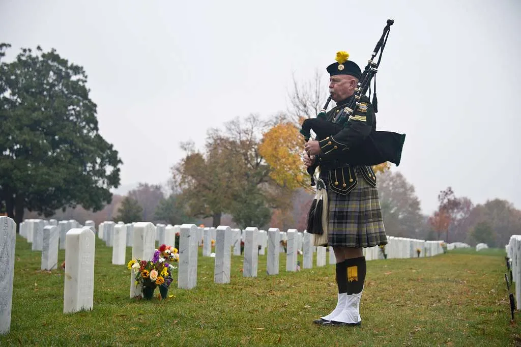 one bagpipe player playing in a funeral