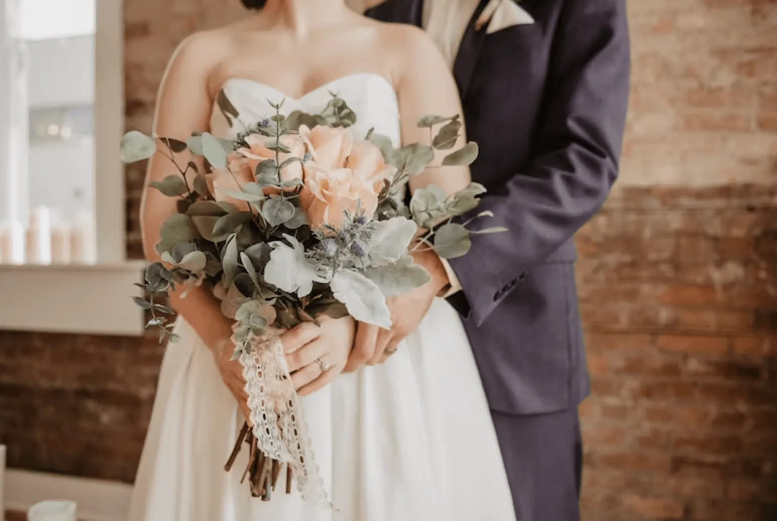 close up of bride and groom, bride holding flowers