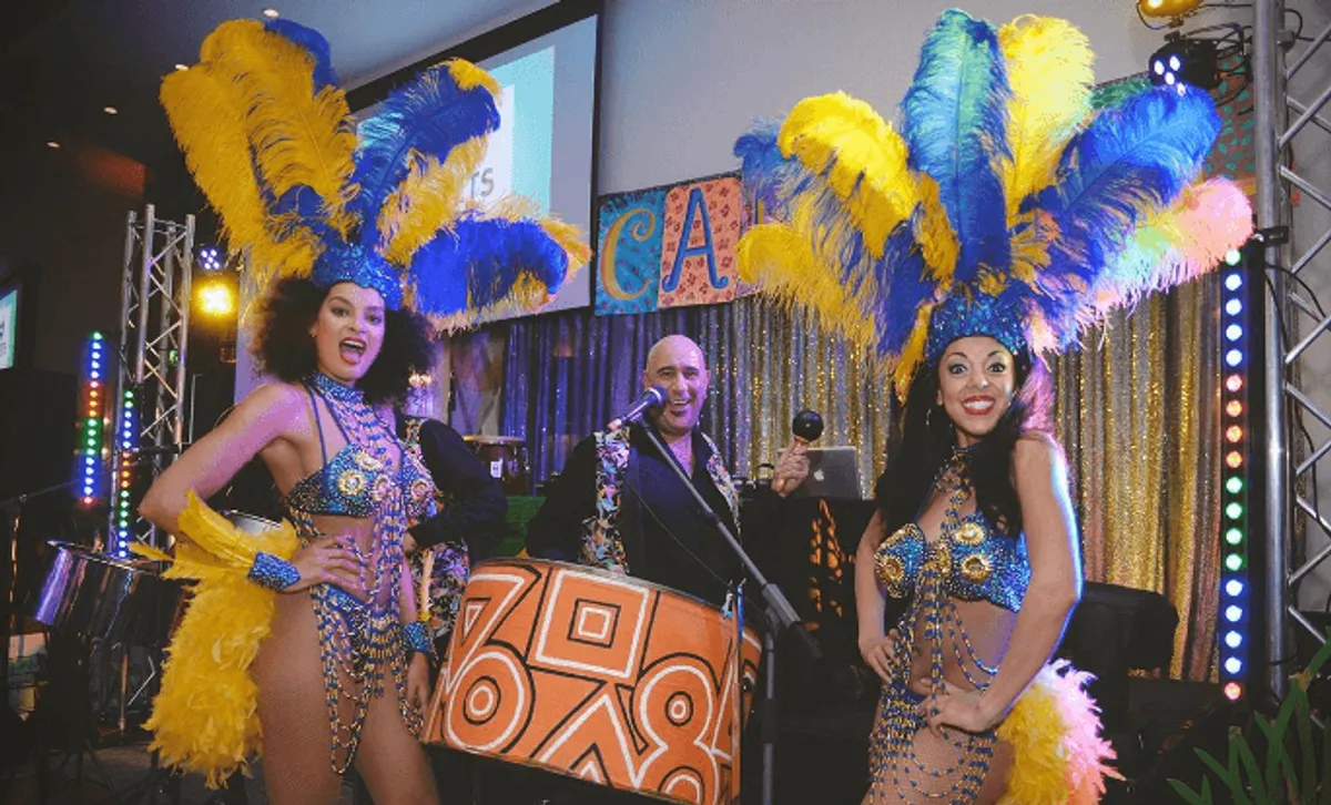 steel pan drummer with two girls in Caribbean festival outfits