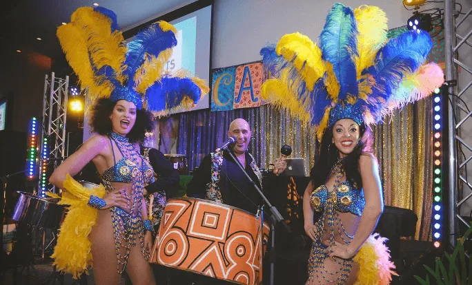 steel pan drummer with two girls in Caribbean festival outfits