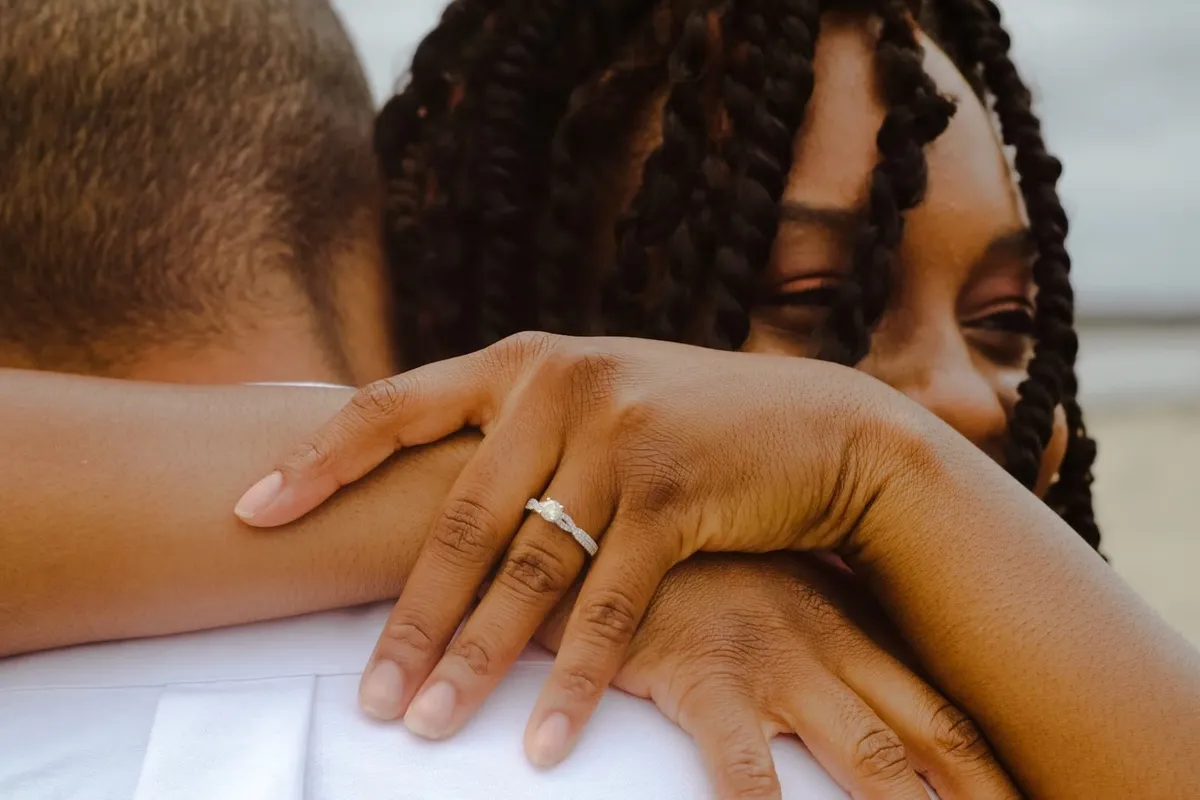 close up of woman and man hugging with woman wearing an engagement ring
