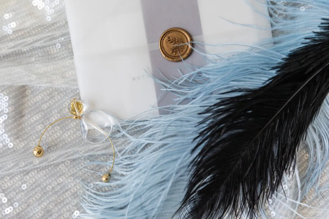 close up of invitations with feather 