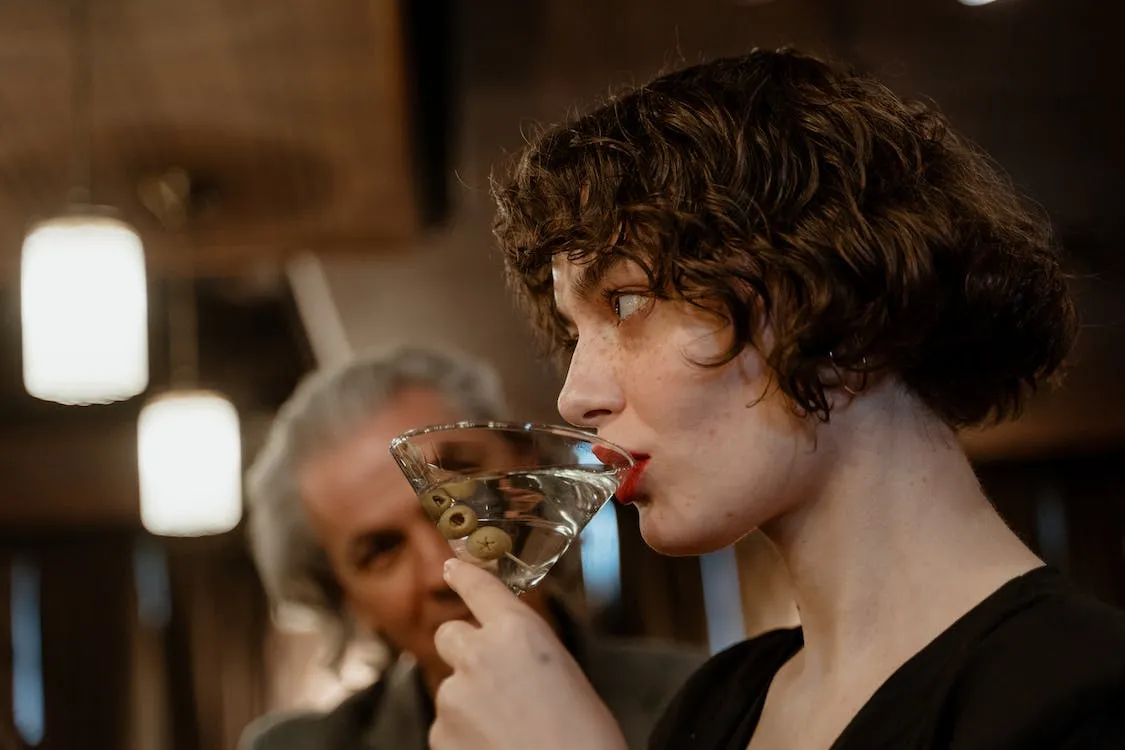 close up of woman drinking a martini
