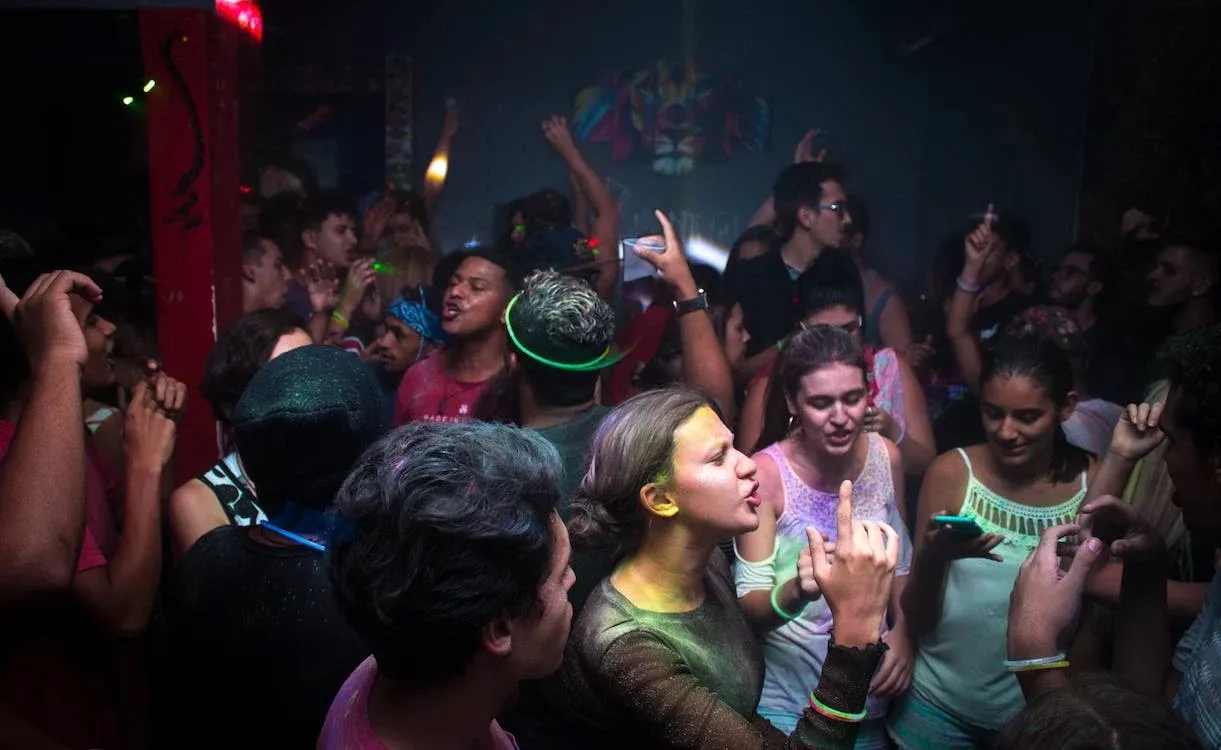 friends in a neon nightclub party with glow sticks