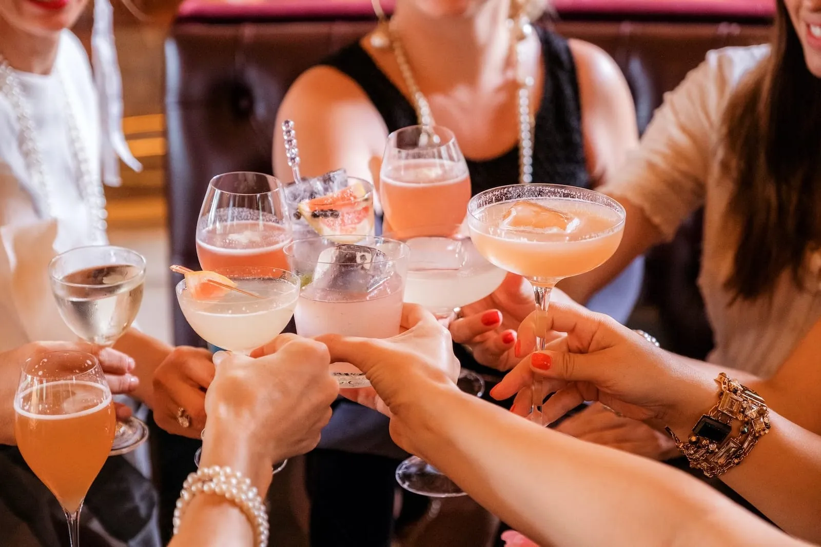close up of group of people cheersing with wine with party music