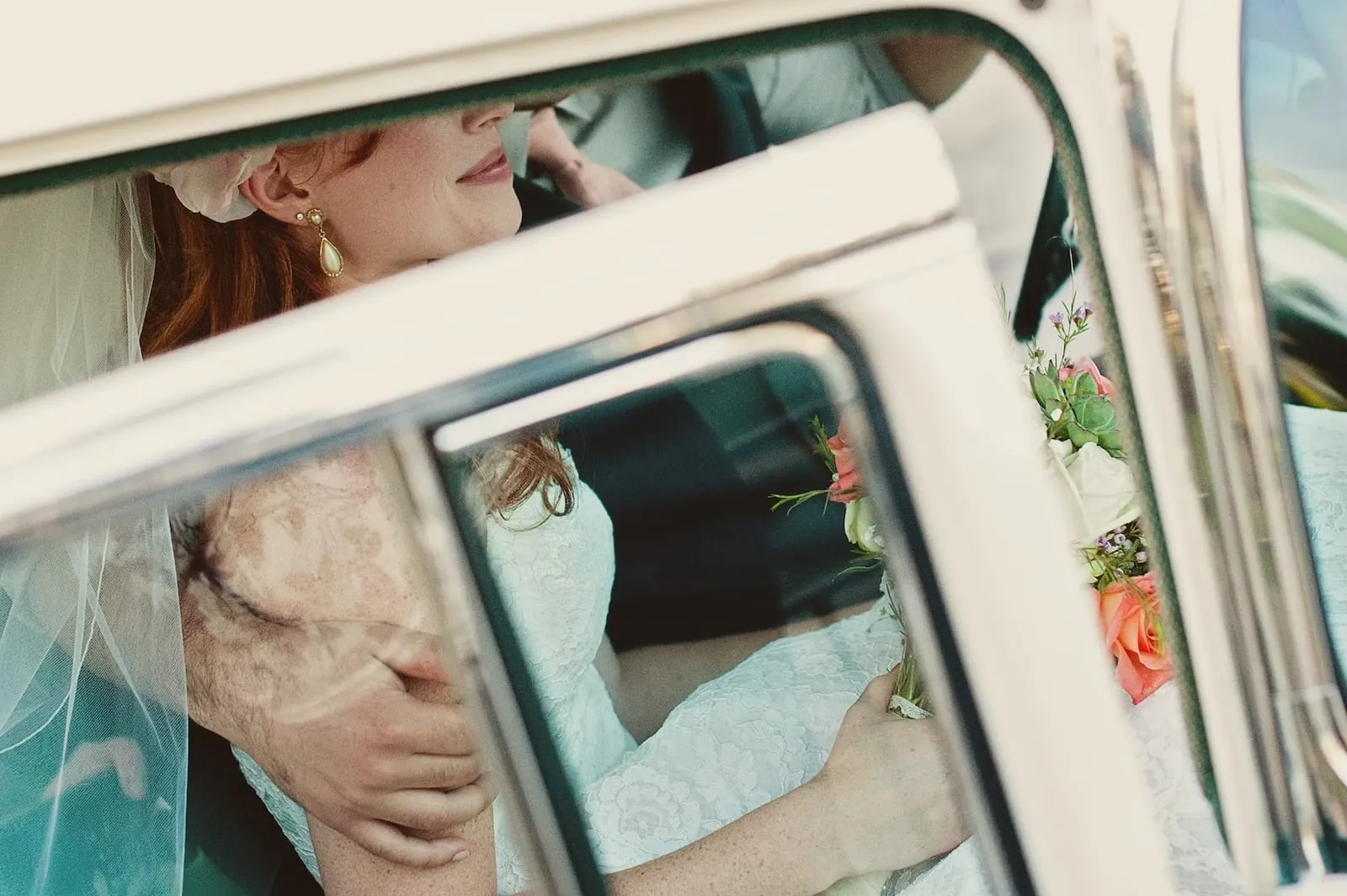 close up of bridge and groom in their vintage wedding car